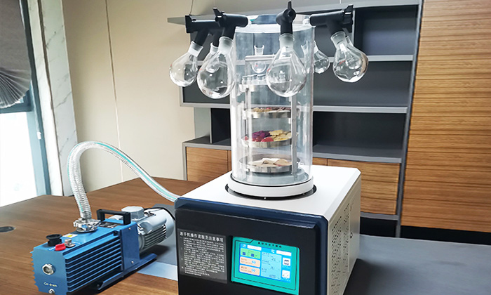Geliss laboratory freeze dryer history in 2020 - compact benchtop lyophilizer machine with digital control panel drying vials in a biotech and pharma research lab